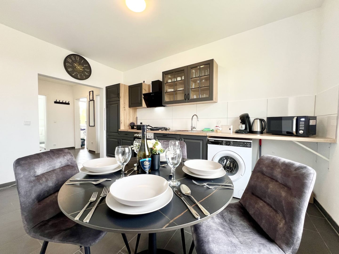 Dining area with round table and modern kitchen in the 3-bedroom apartment in Essen