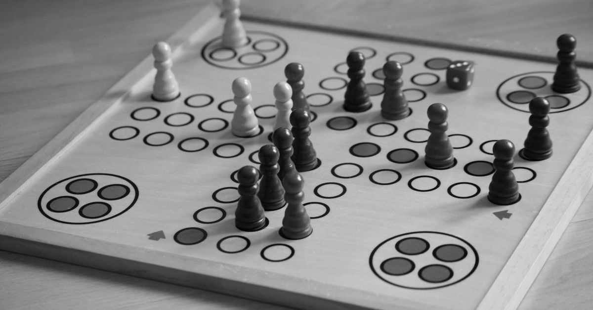 Familie spielt abends gemeinsam ein Brettspiel am Tisch