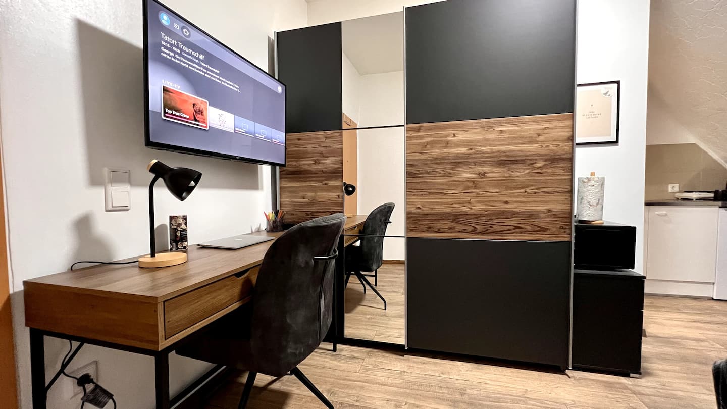 Studio-Apartment mit Schreibtisch, Smart-TV und Kleiderschrank mit Spiegelfront