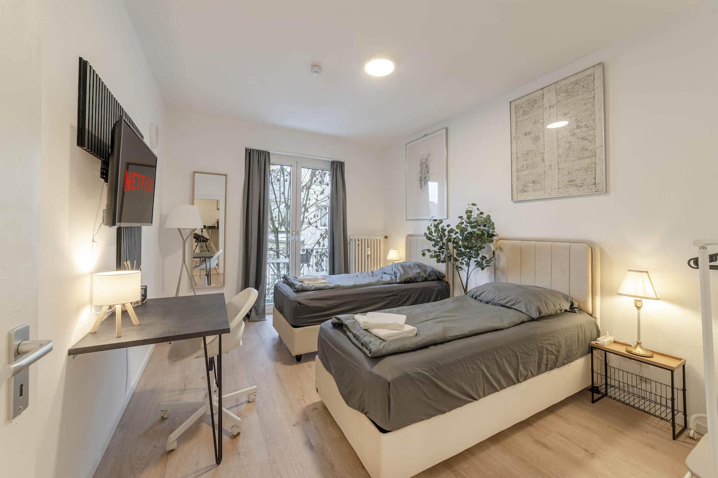 Helles Schlafzimmer mit zwei Einzelbetten, Smart-TV und Balkontür in der Wohnung für 6 in Essen
